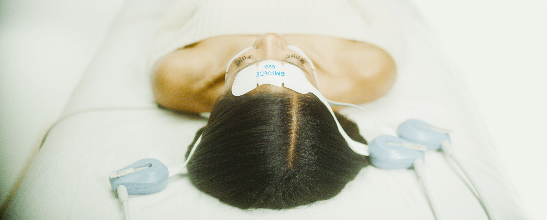 A person is laying on a bed with a mask on their face.