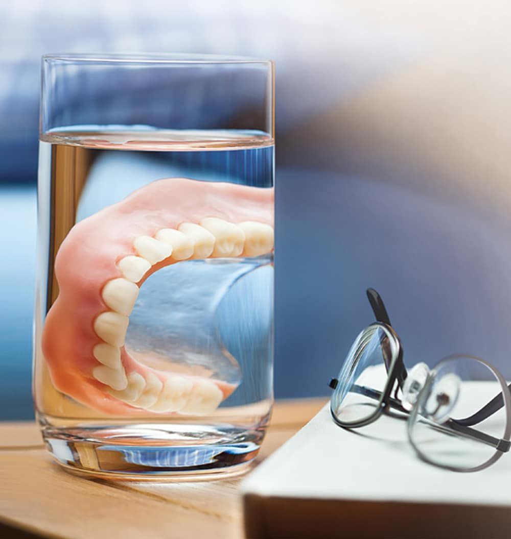 A glass of water with a denture in it