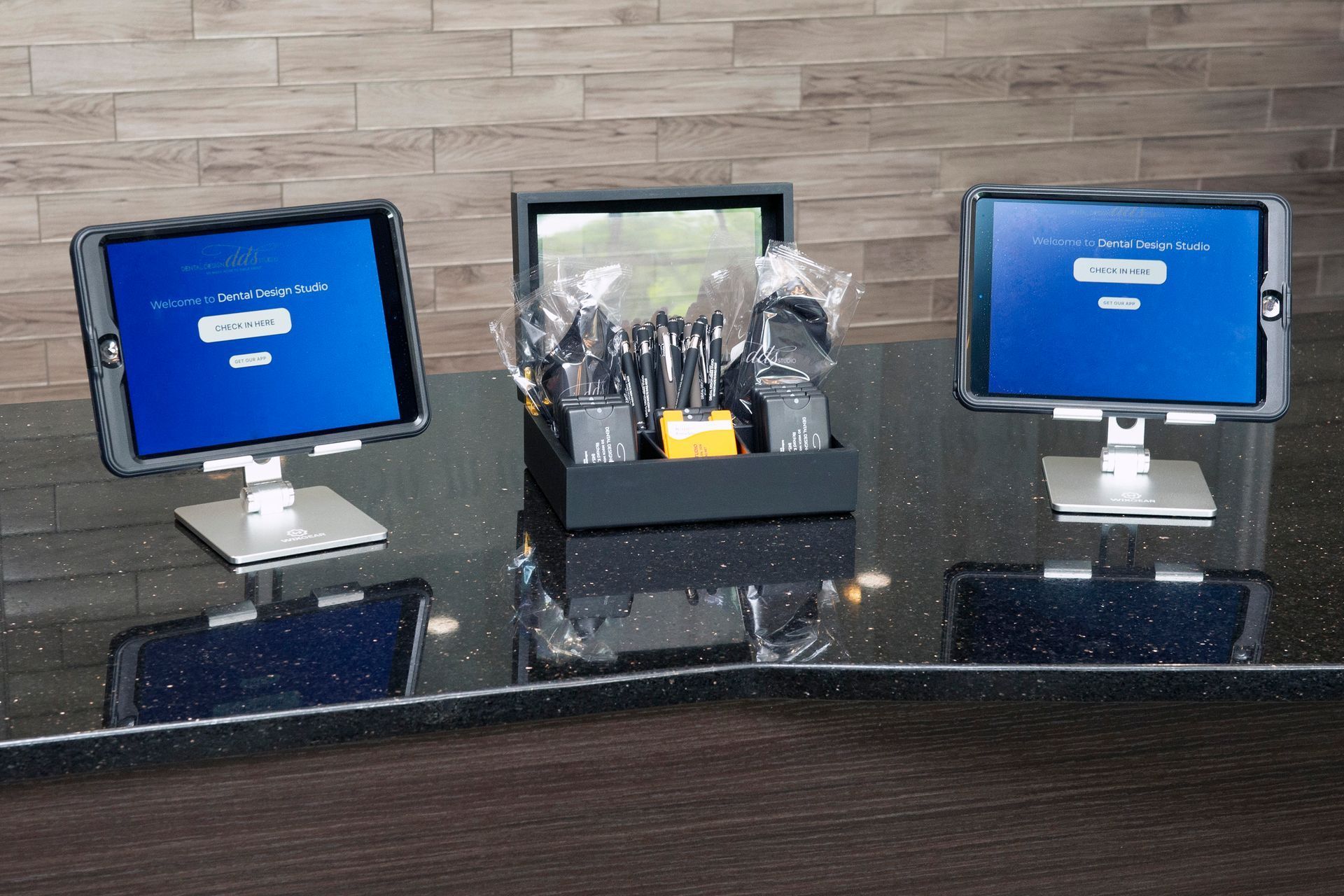Two tablets are sitting on a table with a box of keys on it