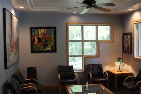 A waiting room with chairs and a ceiling fan.