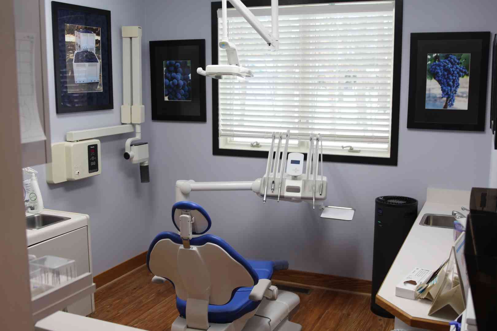 A dental office with a dental chair and a sink.