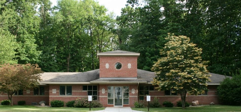 A large brick building with a tree in front of it