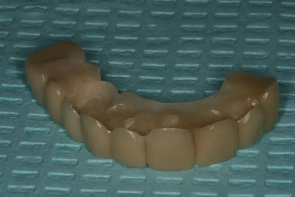 A denture is sitting on a blue table cloth.