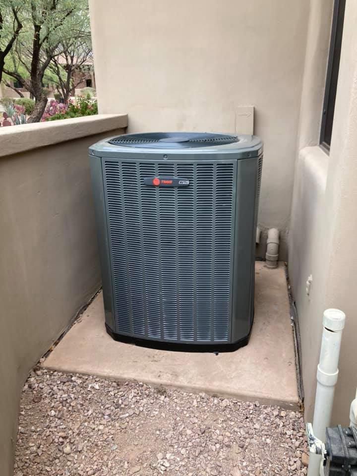 A large air conditioner is sitting on the side of a building.