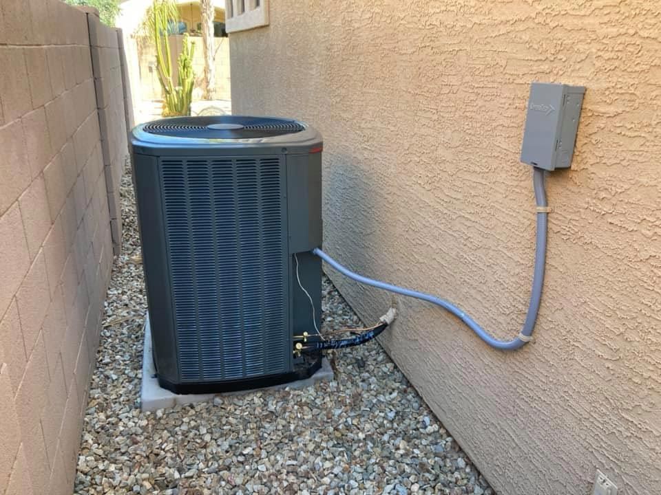 An air conditioner is attached to the side of a building.