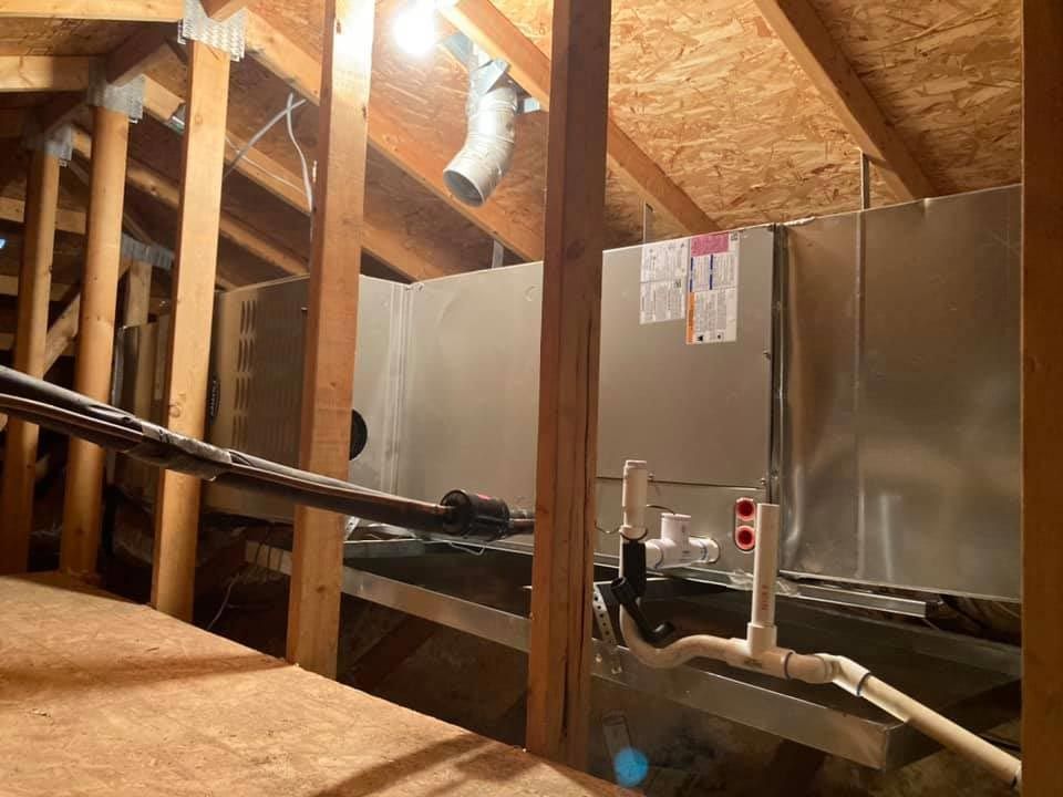 A room with a lot of pipes and a refrigerator in it.