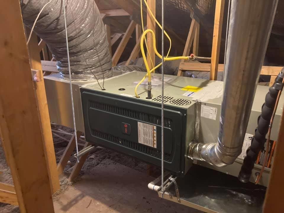 An air conditioner is sitting in the attic of a house.