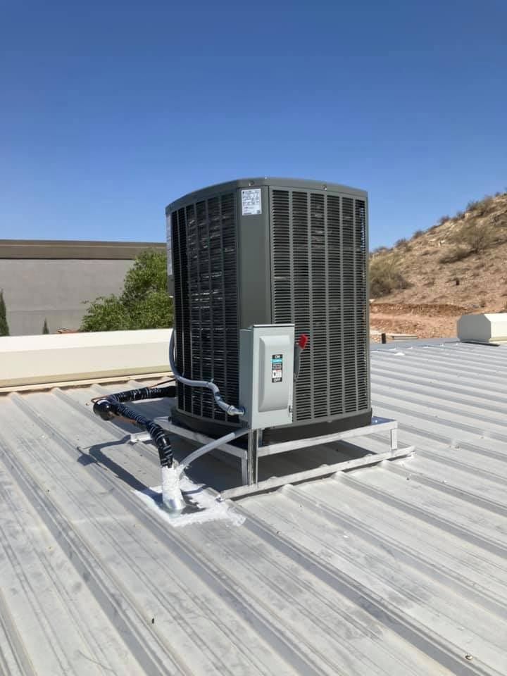 A large air conditioner is sitting on top of a metal roof.