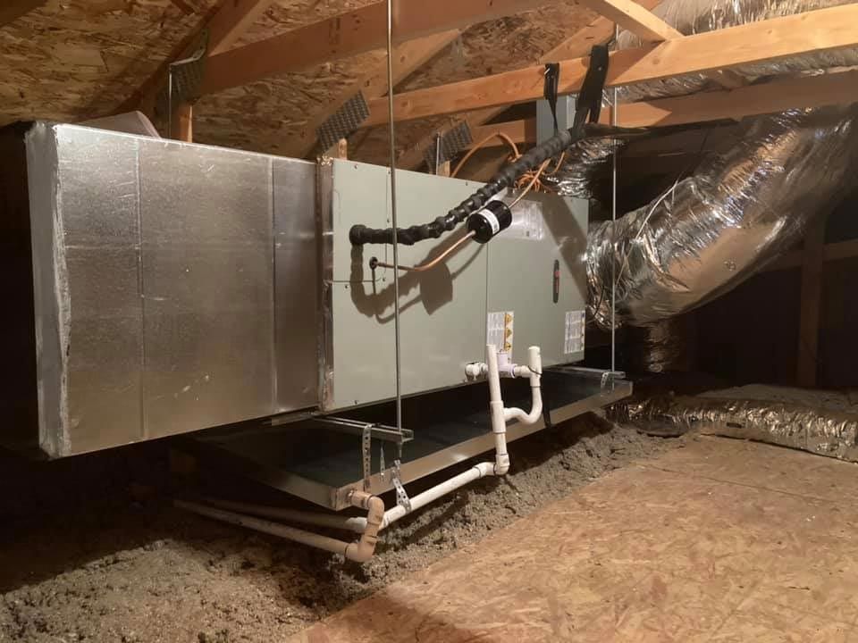 An air conditioner is installed in the attic of a house.