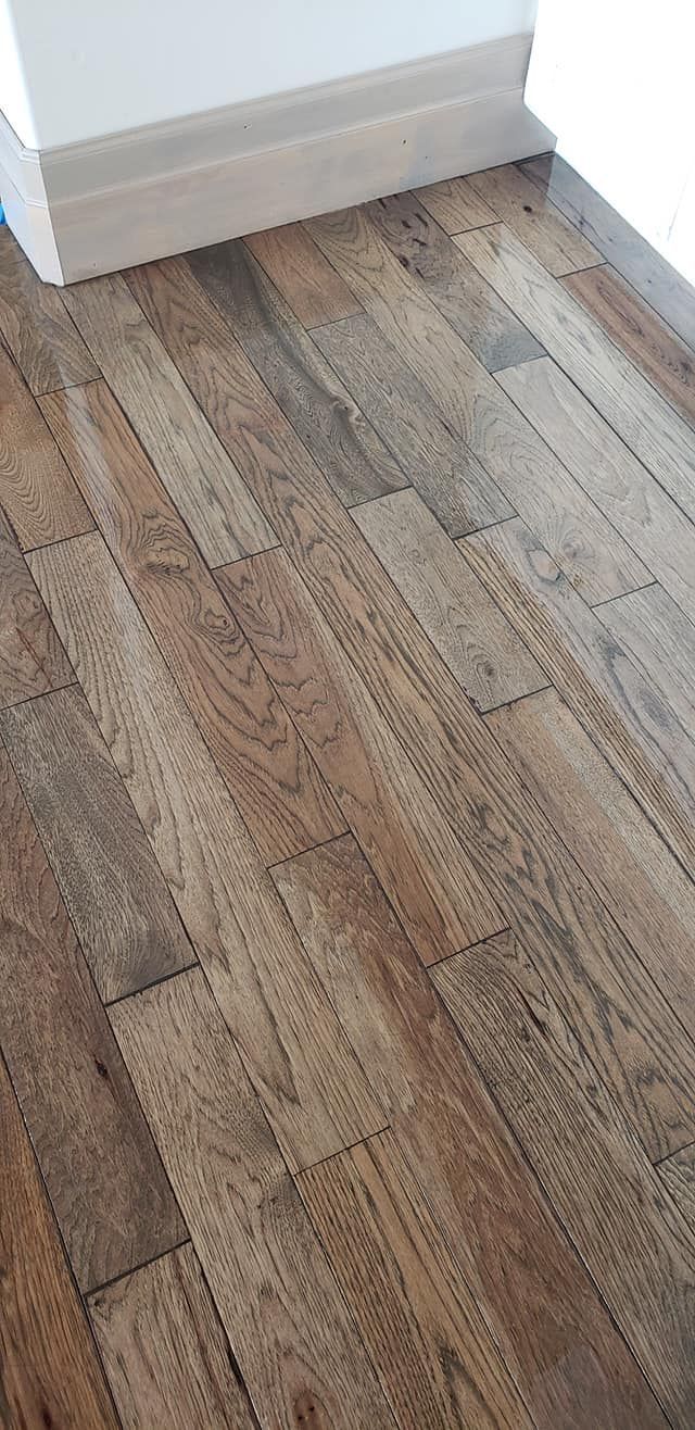 Wooden floor with a white baseboard in a room.