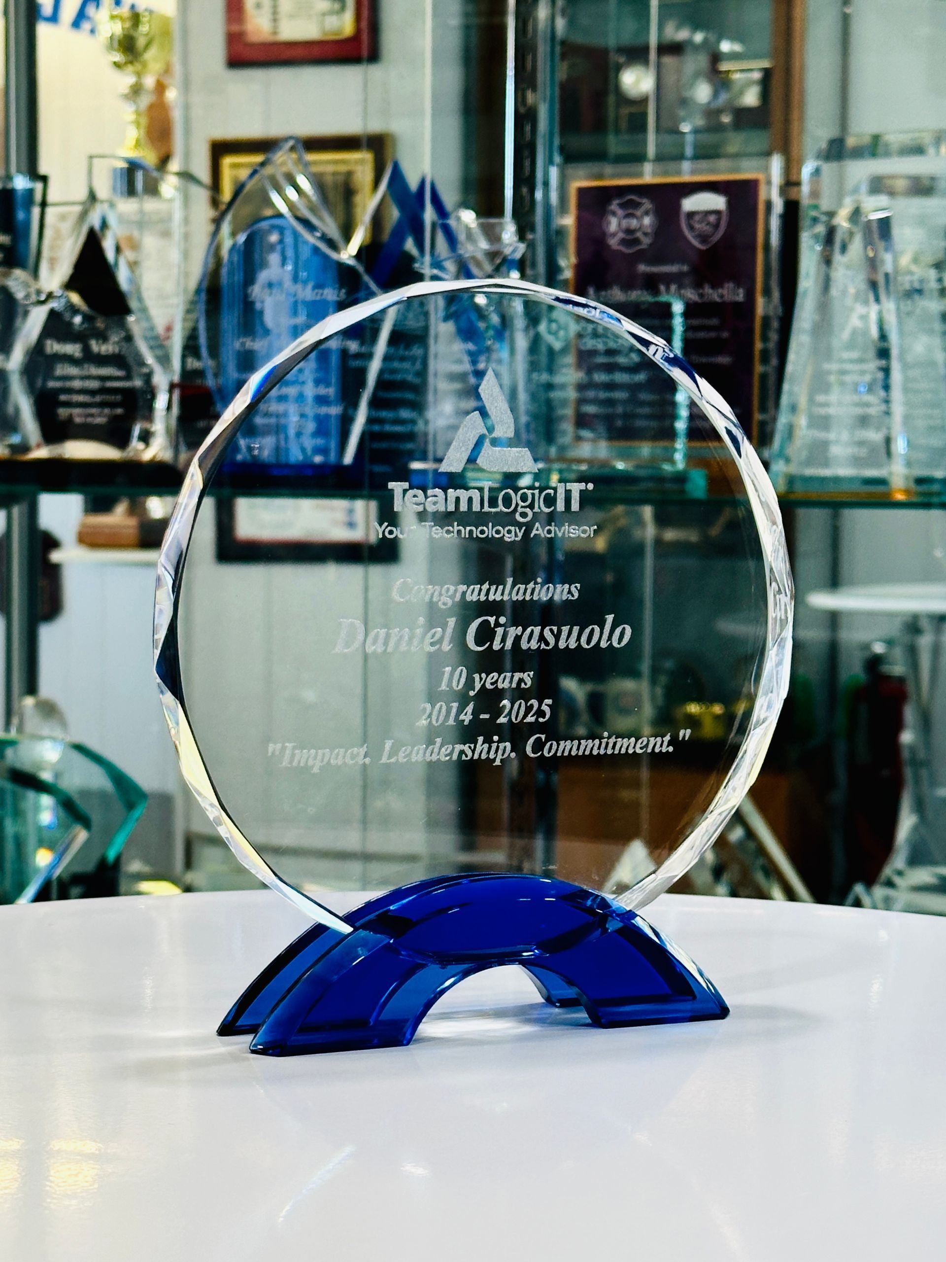 Crystal award on a blue base, inscribed with TeamLogic IT and Manuel Ciraxusdo 2023-2025 for Integrity, Leadership, Conscientiousness.