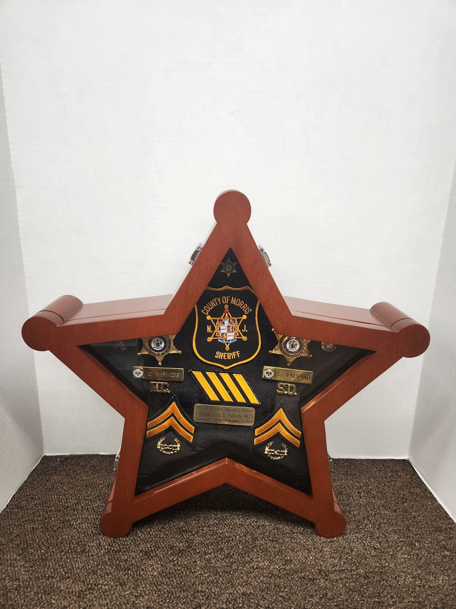 Star-shaped wooden display case holding police badges and insignias.