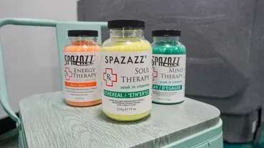 Three supplement bottles on a mint green stool, including Spazazz and a green-lidded bottle.