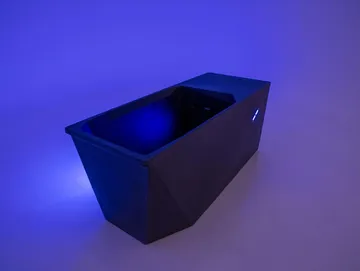Black rectangular planter box lit by blue light on a plain background