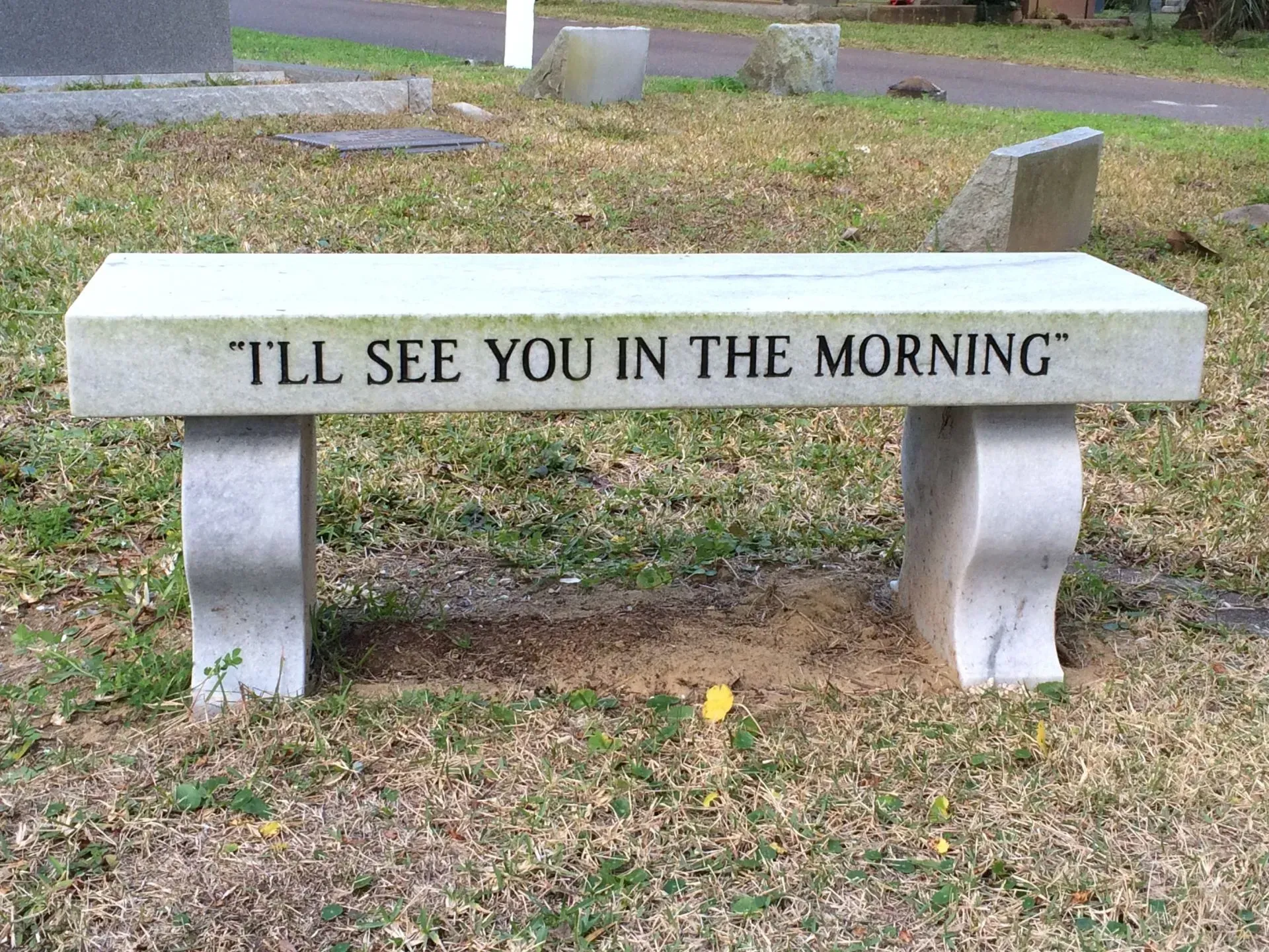 Stone bench in a cemetery, inscribed with 
