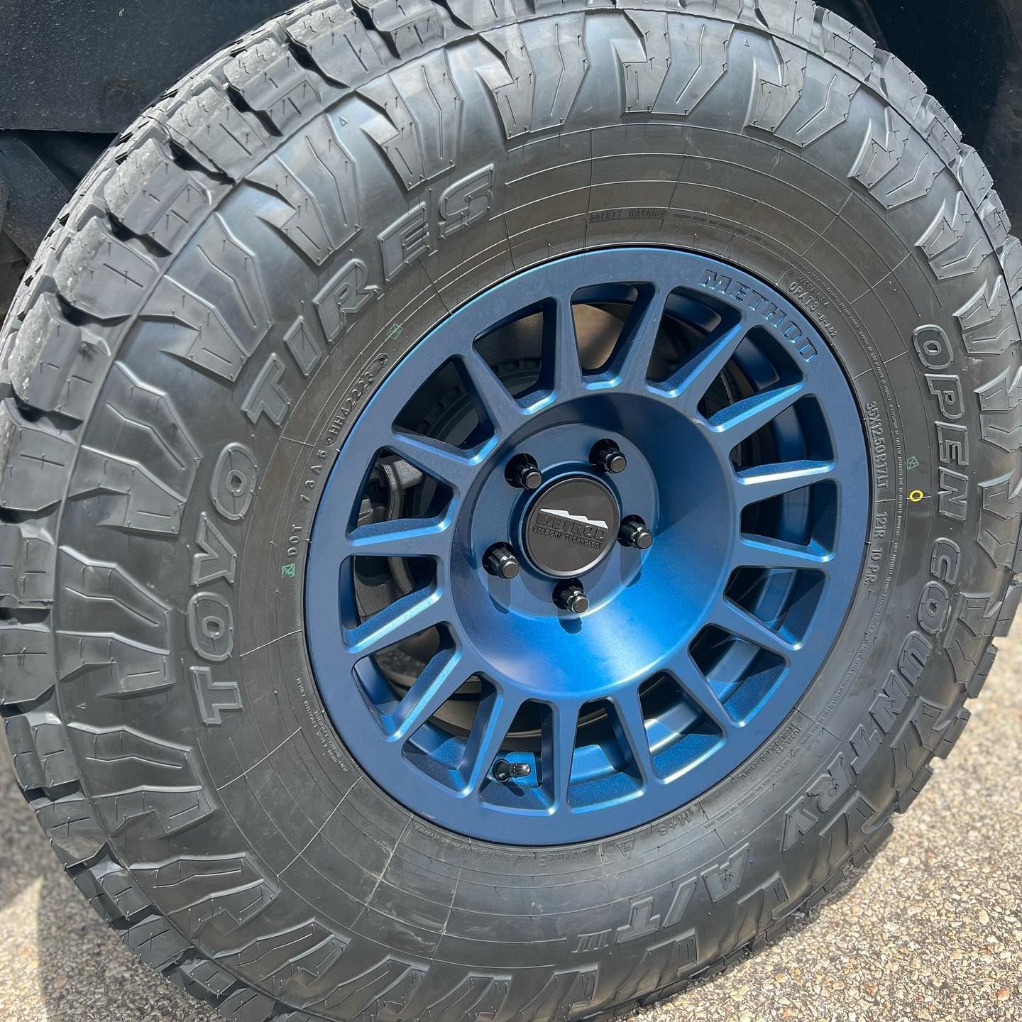 A close up of a tire with a blue rim on a truck.