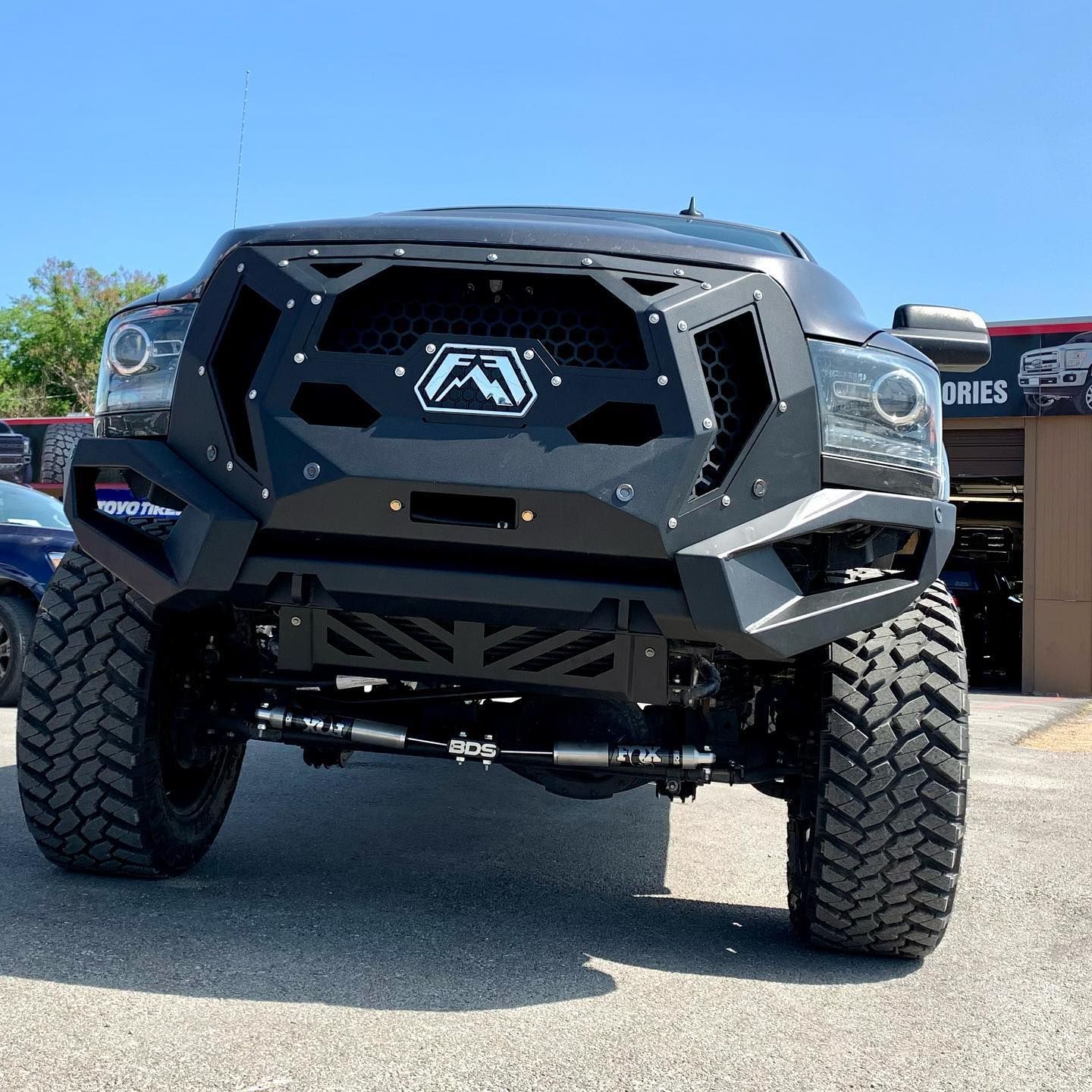 A black truck is parked in front of a garage.