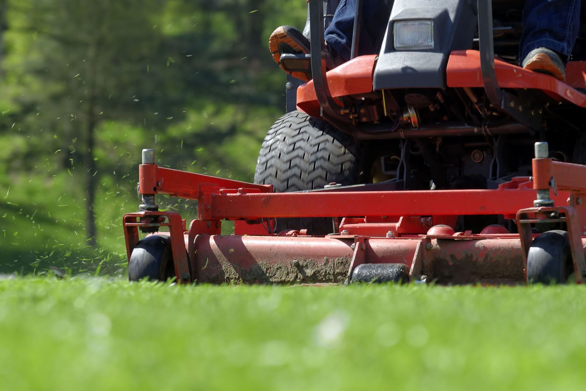 a man is riding a lawn mower on a lush green field