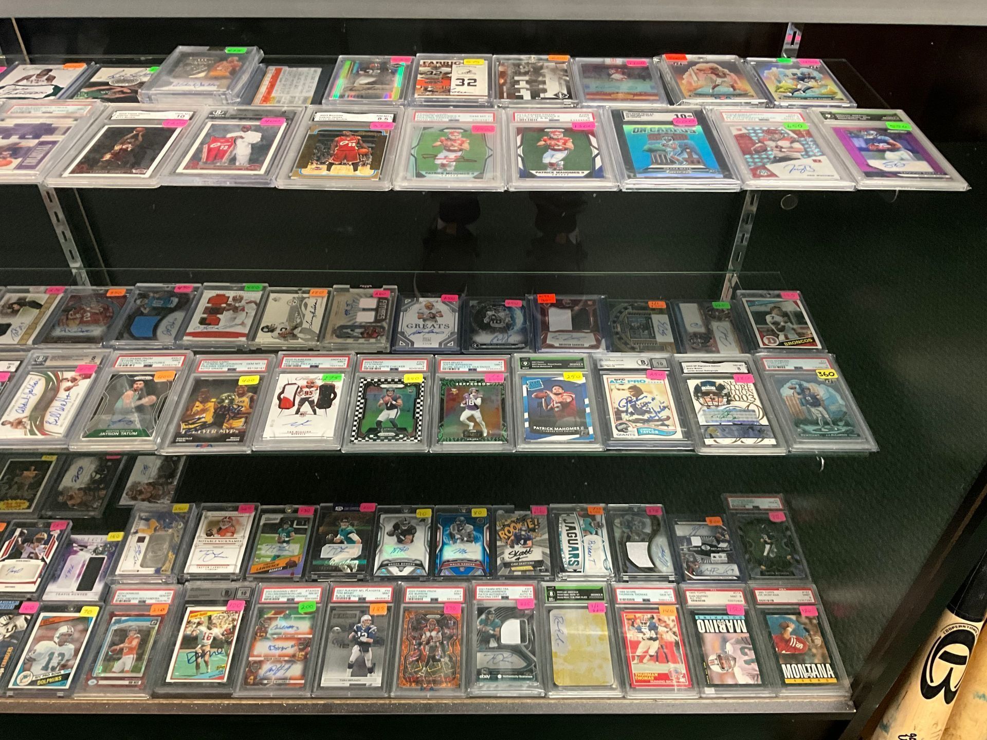Shelves displaying rows of encased sports trading cards.