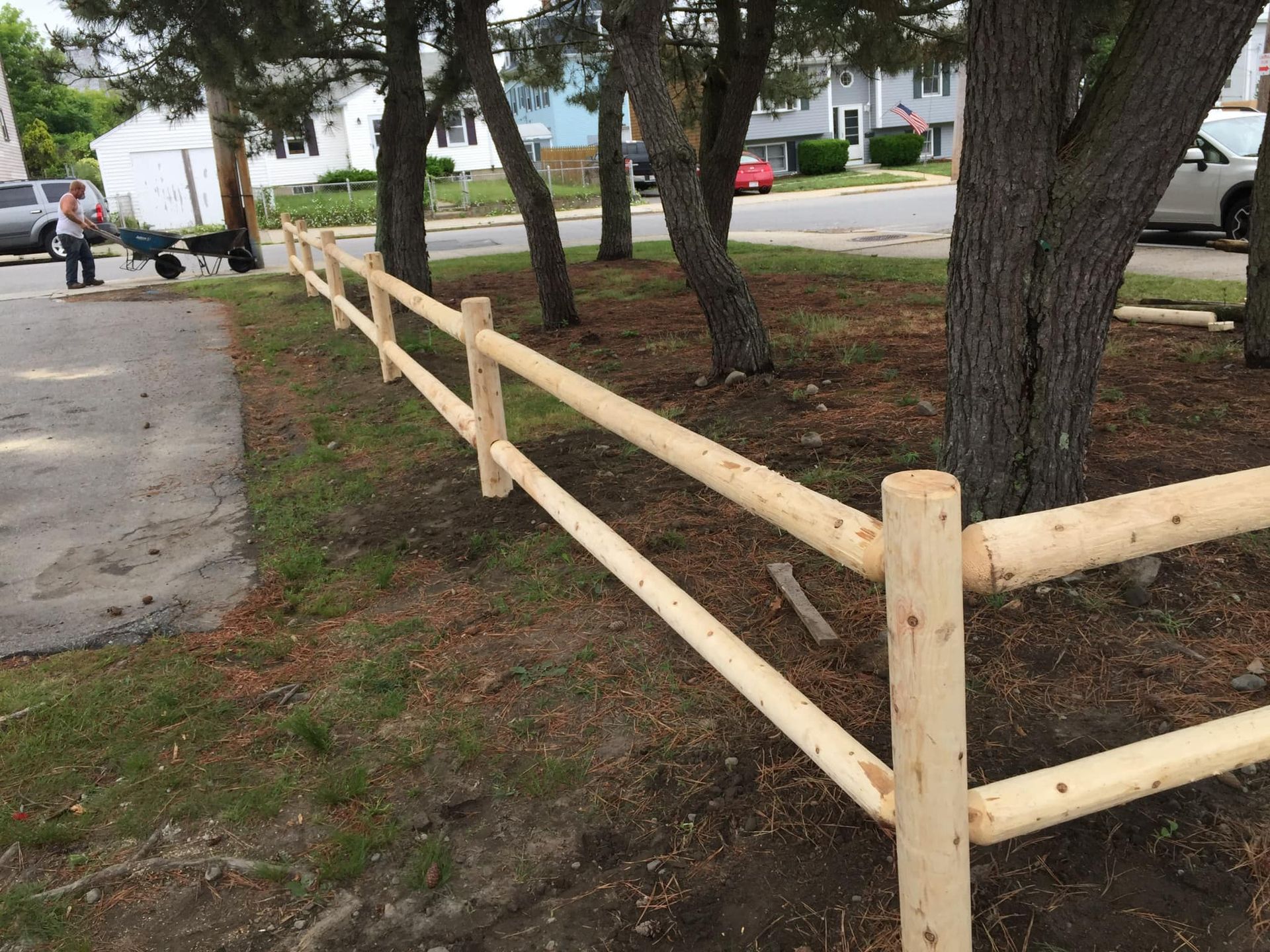 a wooden fence is surrounded by trees in a park
