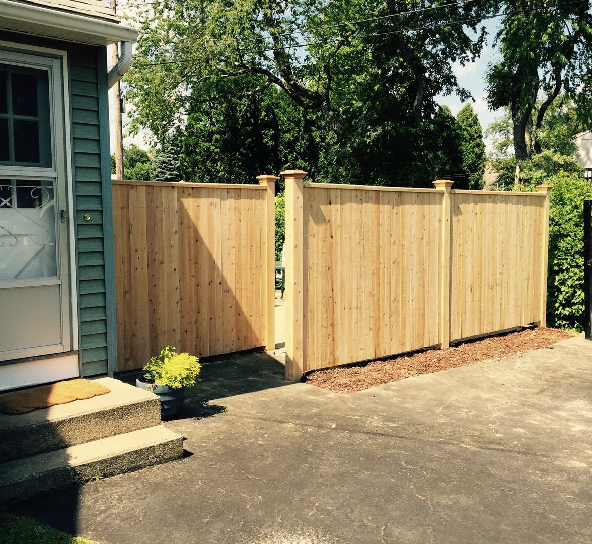 A wooden fence in front of a house, providing privacy and security to the property.
