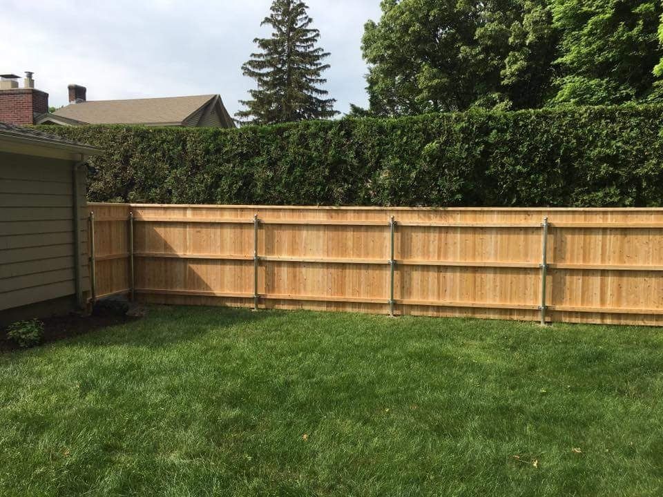 A backyard with a wooden fence and a yard.
