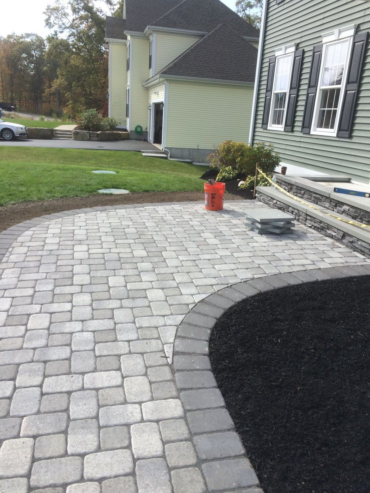 A brick pathway with green lawn.