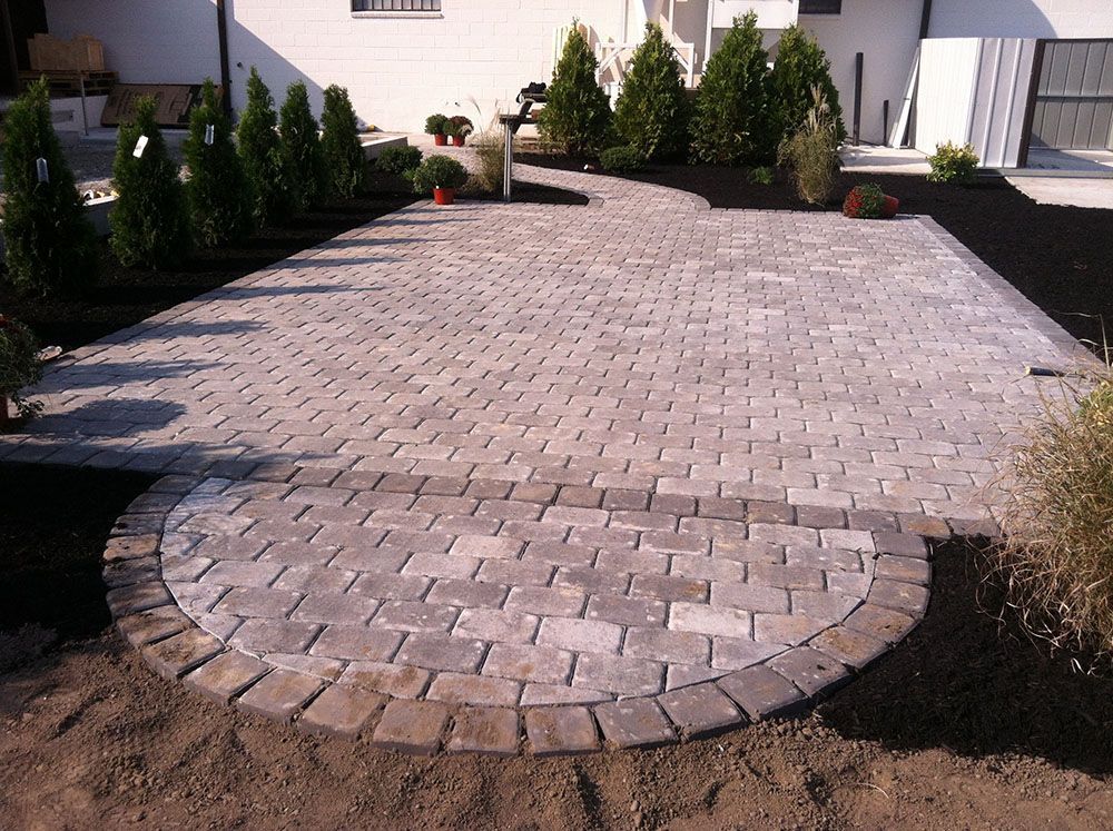 A brick pathway winds through a landscaped patio.