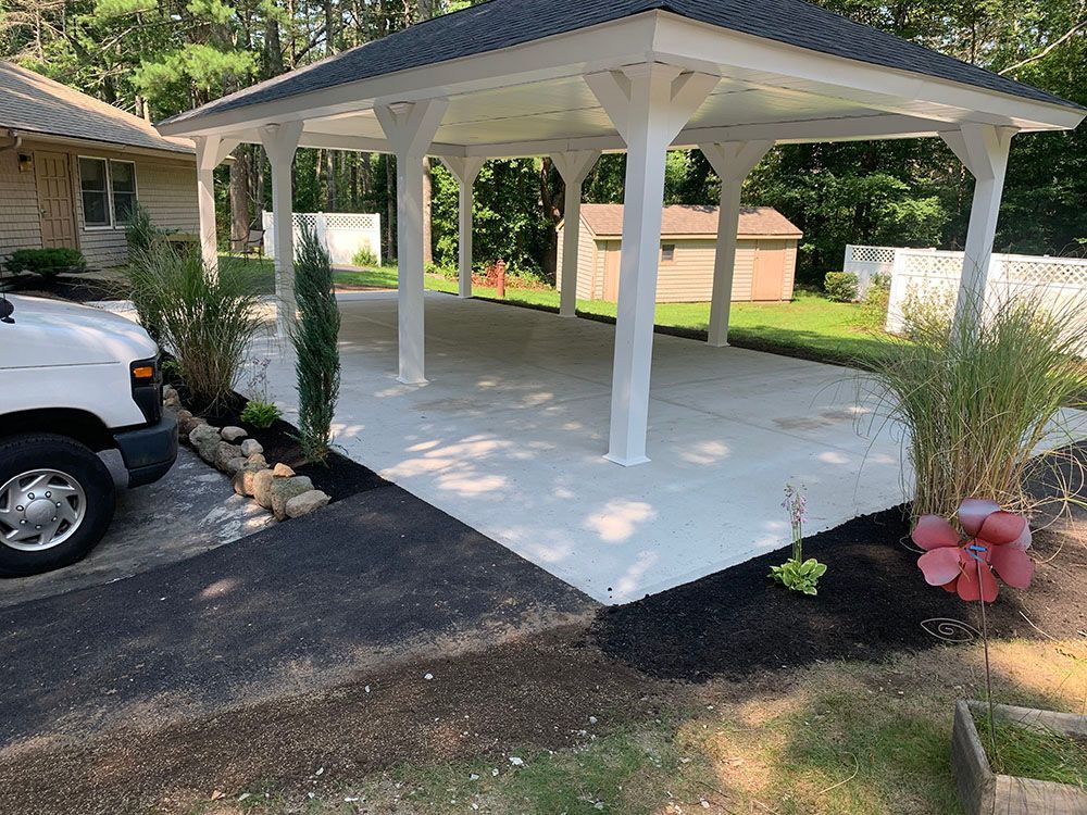 A serene white gazebo stands gracefully in the center of a well-maintained yard.