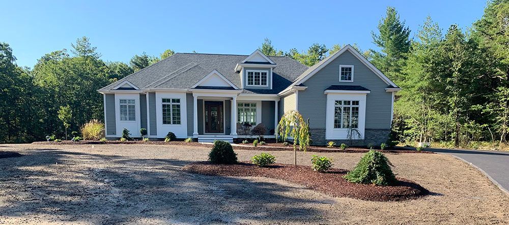 A residential house with a driveway and a gravel area in front.
