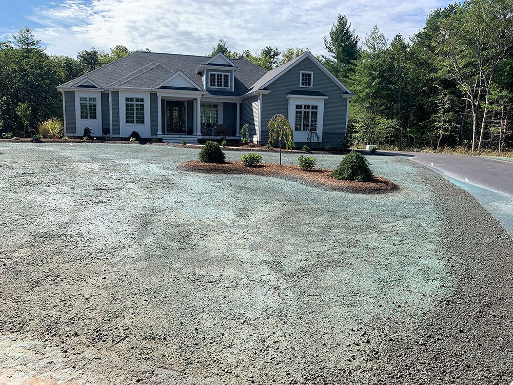Home featuring driveway and gravel patch.