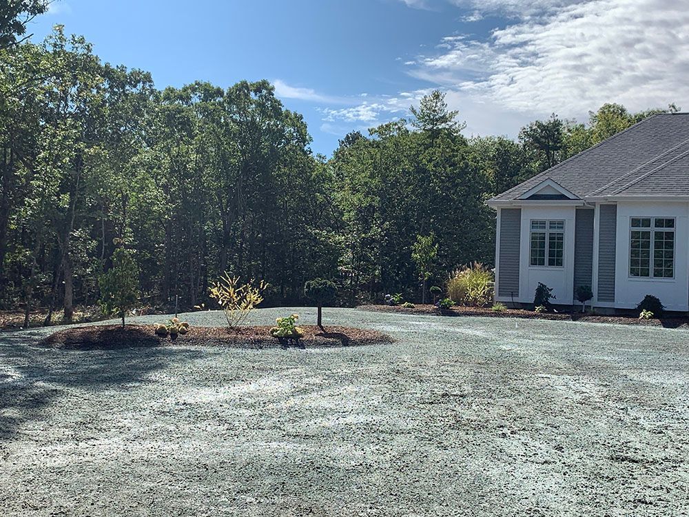 A house with a driveway and gravel area.