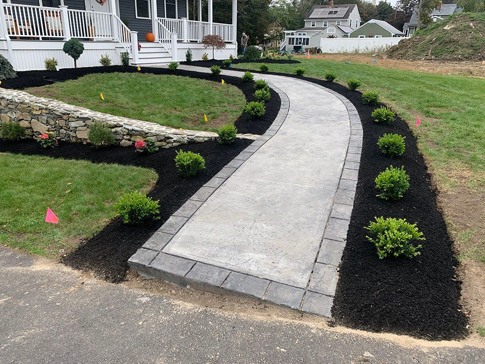 Beautifully landscaped front yard with mulch, showcasing a mix of flowers and greenery.