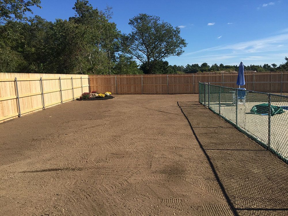 Wooden fence with closed blue umbrella.