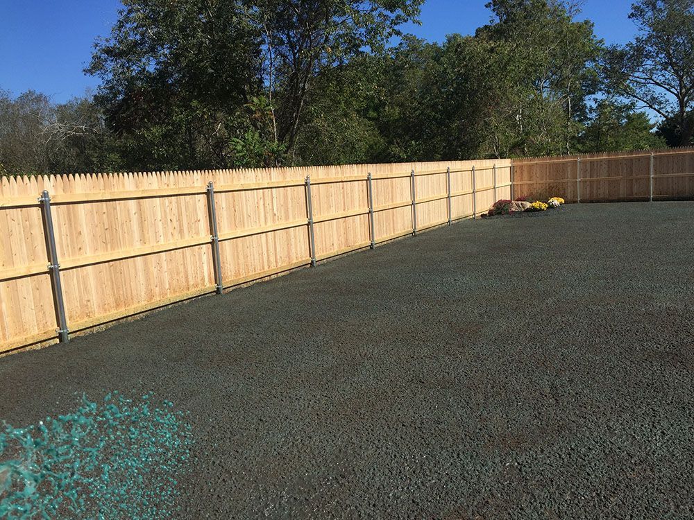 Driveway with gate and wooden fence.