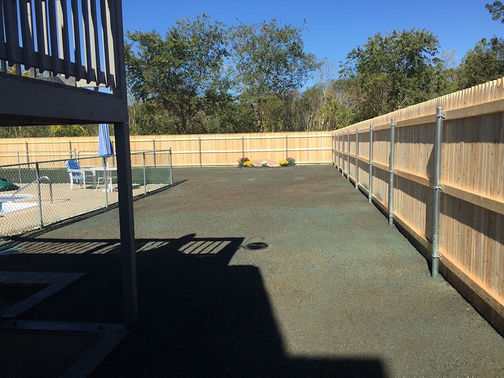 A wooden fence with a pool in the background.