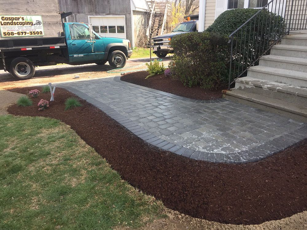 A brick path and blue truck.