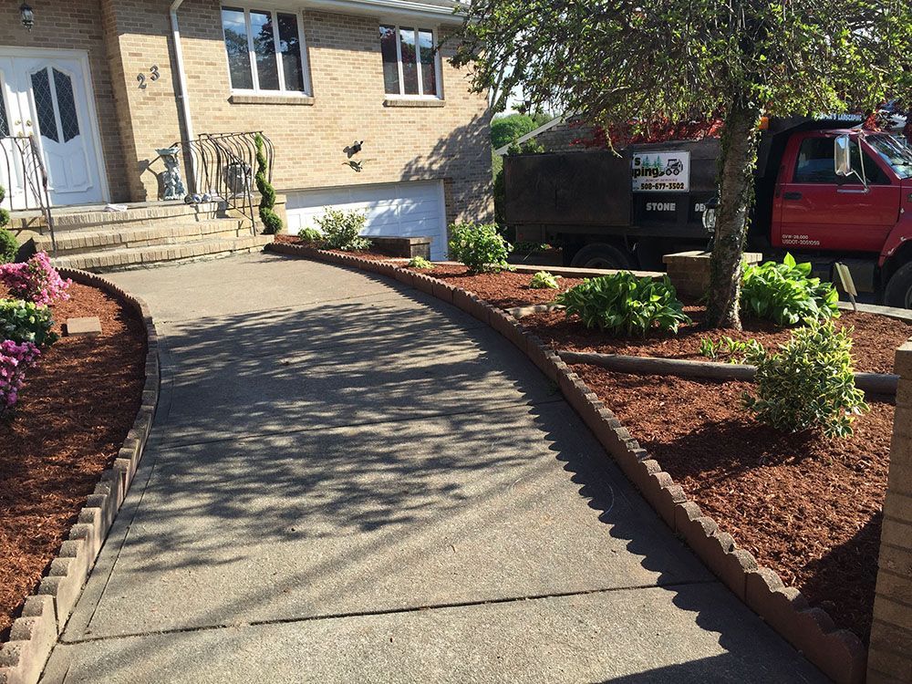 House with concrete walkway and plants.
