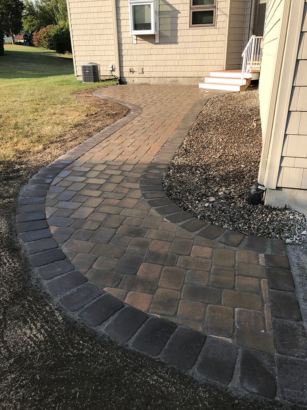 A concrete walkway on the side of a house.