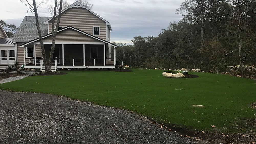 House with gravel driveway and lawn.