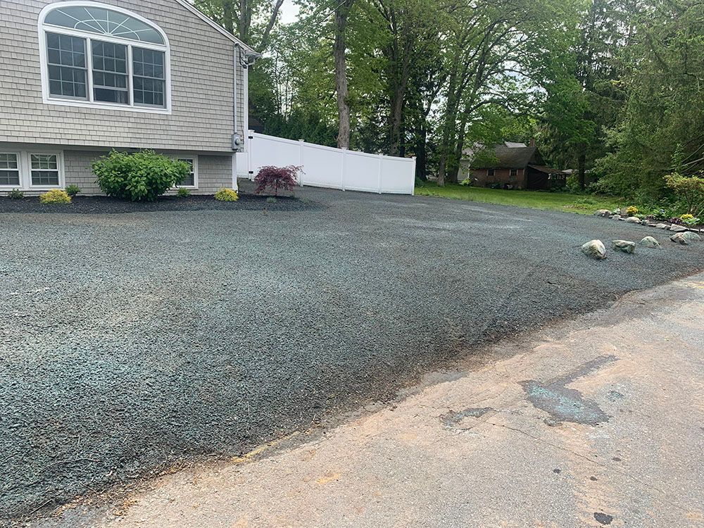 House with trees and gravel driveway.