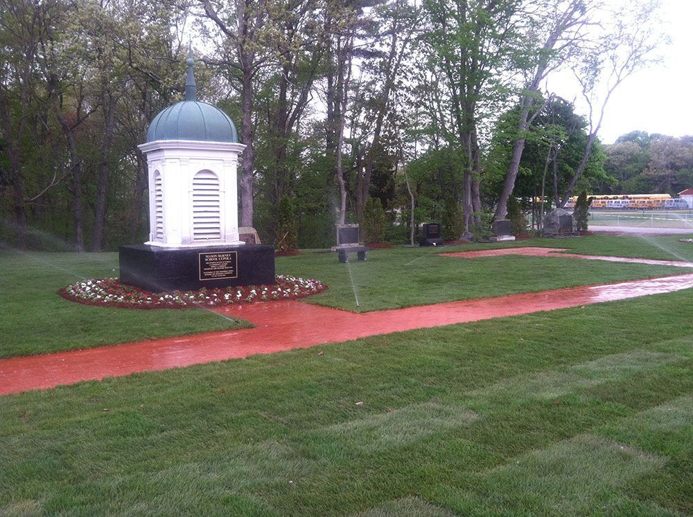 A white dome and a fountain in a serene park, surrounded by lush greenery and offering a tranquil ambiance.