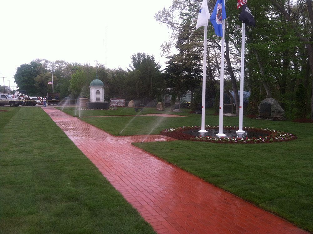Fountain in the middle of a grassy field, creating a peaceful atmosphere.