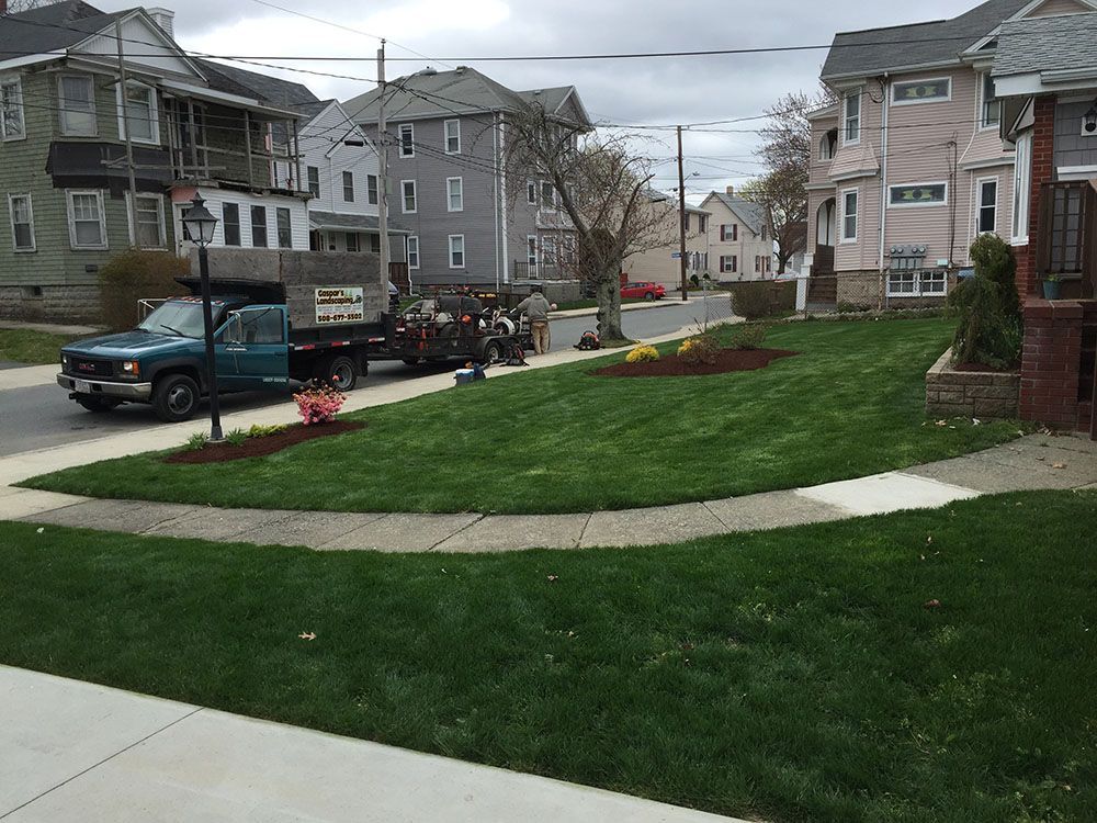 A well-maintained lawn with a charming garden in front of a house.