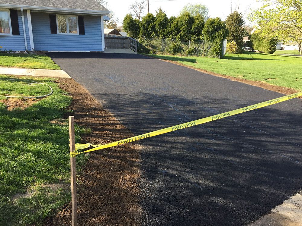 A newly paved asphalt driveway with a smooth surface.