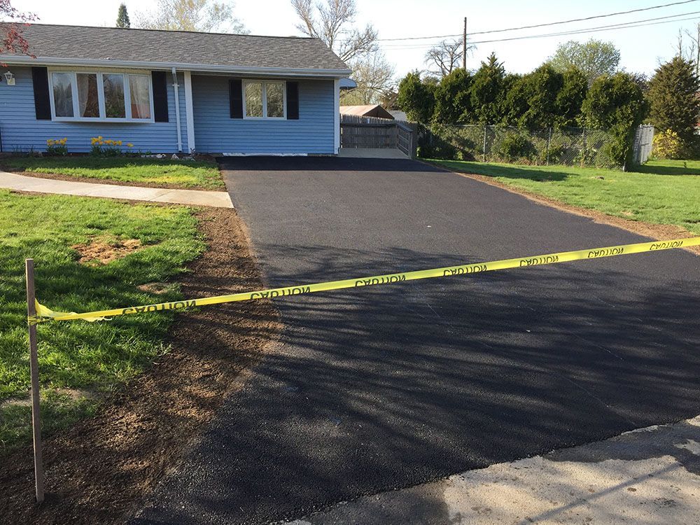 A newly paved asphalt driveway with a smooth surface, ready to welcome vehicles.