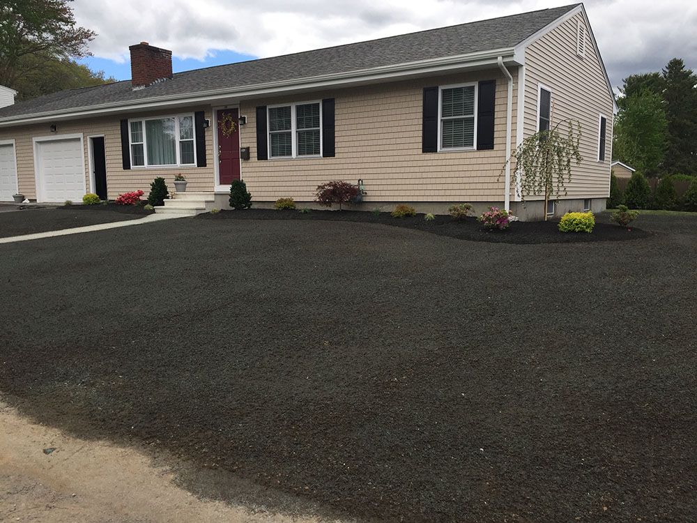 Landscaped driveway with black mulch bed.