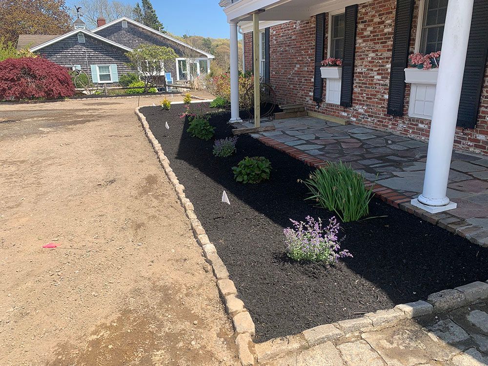 A colorful flower bed enhances the beauty of a house, adding vibrancy and charm to the surroundings.