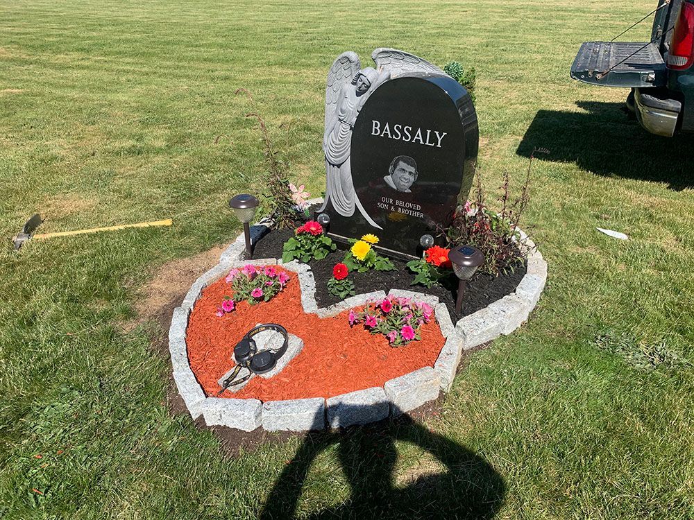 A heart-shaped stone memorial for a man, symbolizing love and remembrance.