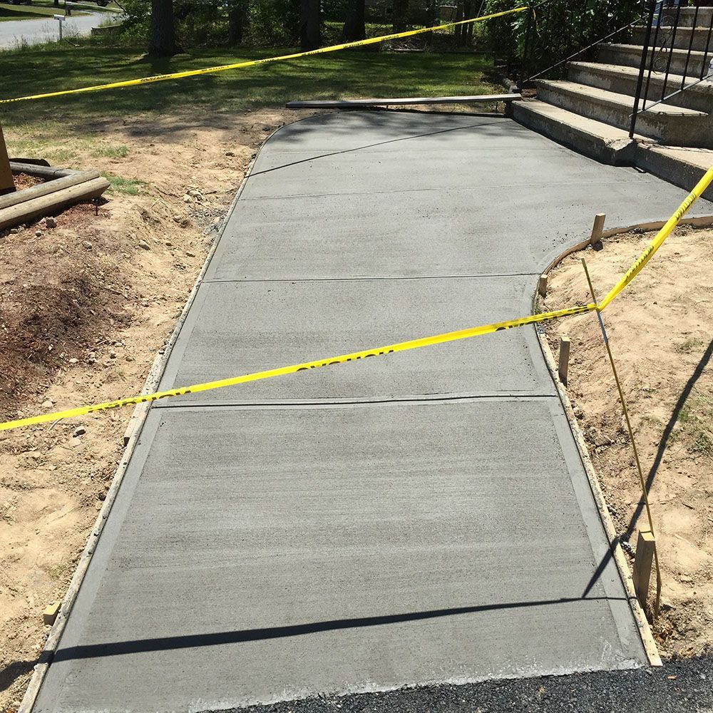 Freshly poured concrete patio in front of a house.